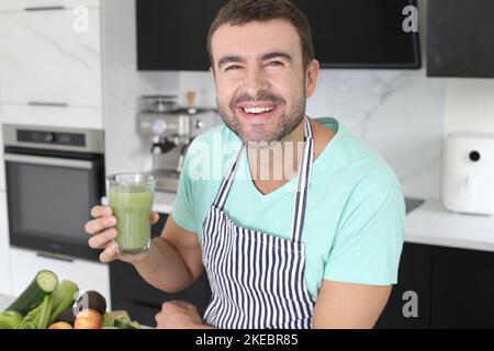 Hombre preparando un jugo verde con ingredientes naturales Foto de stock