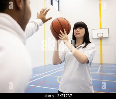 Estudiantes de deportes: Baloncesto. Adolescentes haciendo uso de sus instalaciones deportivas universitarias. De una serie de imágenes relacionadas. Foto de stock