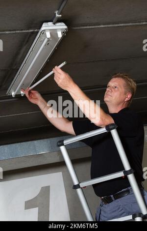 Sustitución de tubos fluorescentes en un garaje, Holanda vvbvanbree fotografie Foto de stock