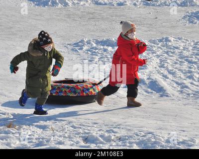 YICHUN, CHINA - 9 DE DICIEMBRE de 2022 - Los niños juegan en la nieve en la ciudad de Yichun, provincia de Heilongjiang, China, 9 de diciembre de 2022. A medida que China optimizó aún más el Foto de stock