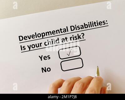 Una persona está contestando la pregunta sobre la infección infantil. Su hijo corre el riesgo de tener discapacidades del desarrollo. Foto de stock