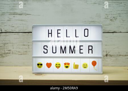 Hola texto de verano en caja de luz sobre fondo de madera Foto de stock