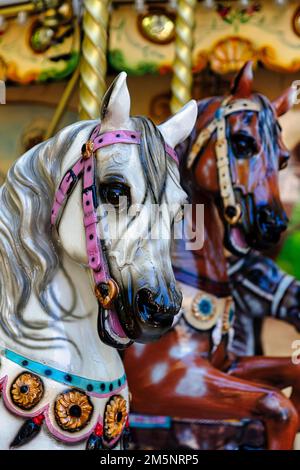 Dos figuras de caballo, cabezas de caballo, caballos en un nostálgico carrusel infantil, primer plano, Francia Foto de stock