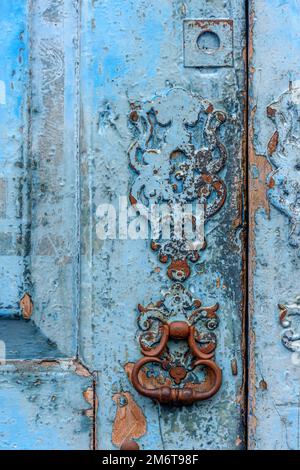 Antigua puerta de madera y cerradura deteriorada por el tiempo y el óxido en una casa de estilo colonial Foto de stock