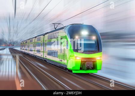 El tren eléctrico de pasajeros conduce a alta velocidad entre la estación urbana de pasajeros, efecto de desenfoque de movimiento Foto de stock