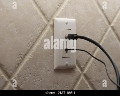 Cable coaxial y cable de teléfono fijo conectado a la toma de pared