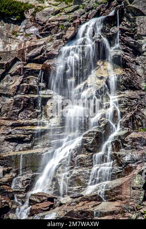 Larga exposición que fluye el agua de la cascada Skok en las montañas del Alto Tatras en Eslovaquia Foto de stock