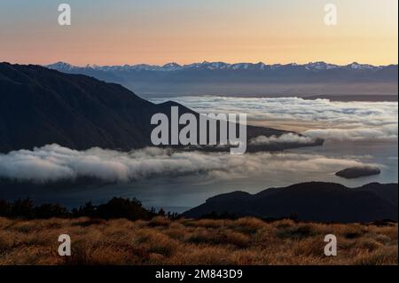 Las nubes se asientan sobre el lago Te Anau al amanecer, visto desde cerca de Luxmore Hut en la pista Kepler Foto de stock