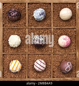 Surtido de chocolates en caja de madera con café en polvo (enfoque manual) Foto de stock