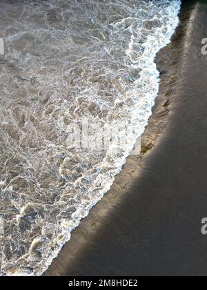 Vista aérea de la inundación que fluye sobre una gran presa en un río. No hay gente. Foto de stock