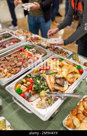 https://l450v.alamy.com/450ves/2m9h4yx/calentar-platos-con-comida-y-gente-que-se-sirve-a-si-misma-concepto-de-evento-buffet-2m9h4yx.jpg