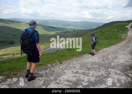 Dos hombres de pie cerca de los Hawes a Kettlewell Road en la Cam High Road (carretera romana) en Wensleydale, Parque Nacional de Yorkshire Dales, Reino Unido. Foto de stock