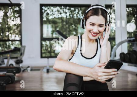 mujer deportiva con auriculares rojos escuchando música para hacer  ejercicio en el gimnasio 16248629 Foto de stock en Vecteezy