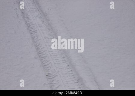Sendero de invierno de una rueda de coche en la nieve, primer plano. Foto de stock