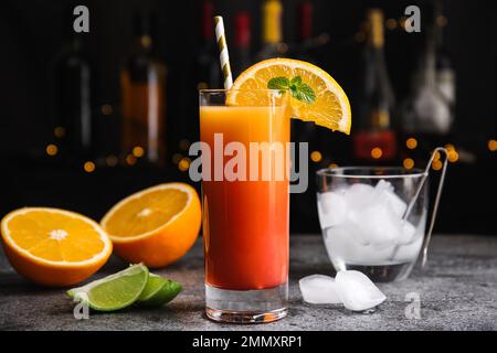 Cóctel fresco alcohólico Tequila Sunrise en mesa gris Foto de stock