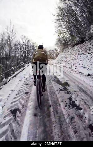 Paseos en bicicleta en la carretera de montaña llena de nieve Foto de stock