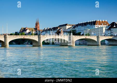 Blick vom Rheinufer entlang der Flusspromenade auf die Altstadt von Basel mit dem Basler Münster, der Martins Kirche, der Mittlere Brücke und dem Rhei Foto de stock