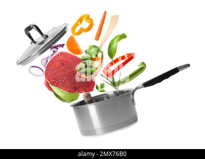 Olla e ingredientes frescos para sopa sobre fondo blanco Foto de stock