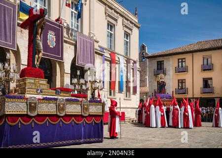 Semana Santa en Palencia, España. Penitentes llevando la imagen de Jesucristo en la cruz por las calles. Foto de stock