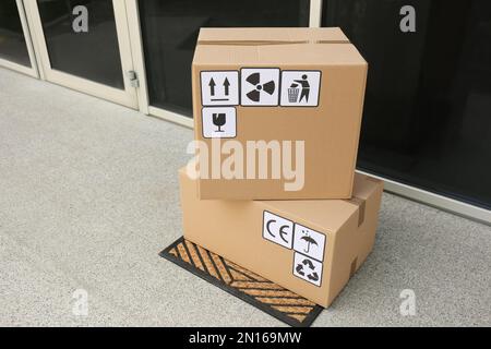 Cajas de cartón con diferentes símbolos de embalaje sobre fondo blanco.  Entrega de paquetes Fotografía de stock - Alamy