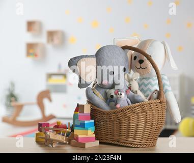 Conjunto de diferentes juguetes lindos en la mesa de madera en la habitación de los niños Foto de stock
