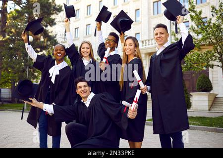 Faulous mujeres jóvenes graduados en elegantes trajes de noche