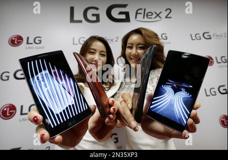 Models pose next to LG Electronics' light-emitting diode television in Seoul January 2013. LG Electronics started taking orders Wednesday for OLED televisions, hoping to take the initiative over