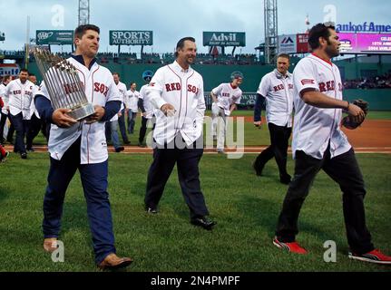 Former Boston Red Sox pitchers Curt Schilling, far right, and Keith Foulke,  holding the 2004 World Series trophy, and catcher Jason Varitek, far left,  applaud as 2004 teammate David Ortiz (34) joins