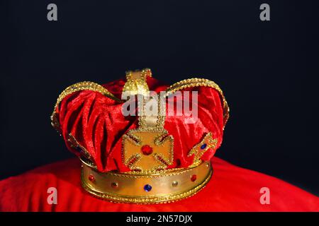 Hermosa corona de terciopelo en almohada roja. Artículo de fantasía Foto de stock
