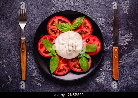 Delicioso queso buratta con tomates frescos, vista de arriba Foto de stock