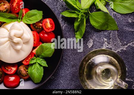 Delicioso queso buratta con tomates frescos, vista de arriba Foto de stock