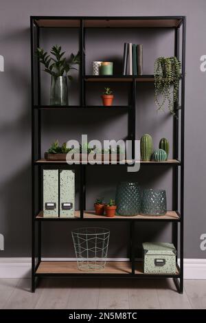 Estantería con libros y decoración cerca de la pared blanca habitación  Fotografía de stock - Alamy