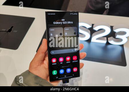 SHANGHAI, CHINA - 10 DE FEBRERO de 2023 - Un cliente prueba el nuevo teléfono insignia de la serie Galaxy S23 en la tienda insignia de Samsung en Shanghai Foto de stock