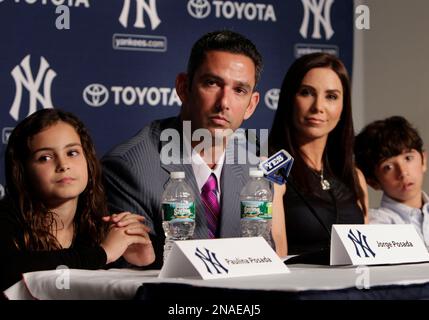 ADDS NAME OF MOTHER - Former New York Yankees catcher Jorge Posada, second  from right, and his wife Laura Posada, third from left, wave to fans while  standing inside Monument Park with