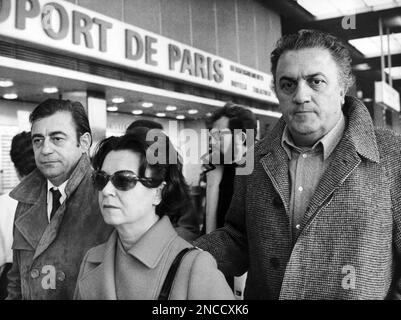 Italian director Federico Fellini, right, arrives at the Paris, France, airport on November 28, 1969, accompanied by his wife, Italian actress Giulietta Masina and French actor Francois Perier, to present his film 'Satyricon'. (AP Photo/Michel Lipchitz)