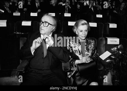 Italian movie director Federico Fellini adjusts his tie, sitting next to his wife Giulietta Masina during the premiere of his latest movie 'Ginger e Fred' on Tuesday night, January 22, 1986 in Rome, Italy. An audience of 2,000 top personalities gave the film a ten minute standing ovation when the lights came on. (AP Photo/Claudio Luffoli)
