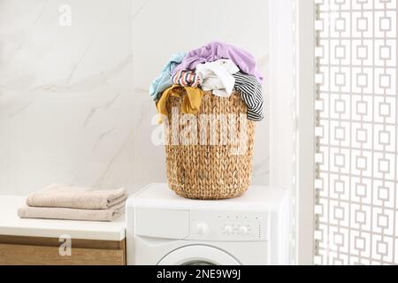 Cesta de mimbre con ropa sucia en el piso interior, espacio para texto  Fotografía de stock - Alamy