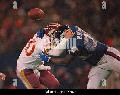 The ball pops free as Washington Redskins quarterback Jay Schroeder is hit  by Giants Leonard Marshall while trying to pass during the third quarter of NFC  Championship game in East Rutherford, N.J.