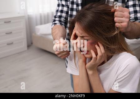 Hombre abusando de la mujer asustada en el dormitorio. Violencia doméstica Foto de stock