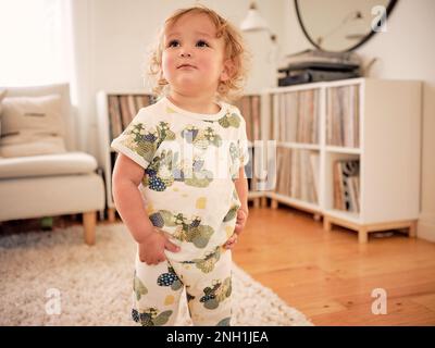 Niño sonriente en ropa de cactus de pie en la sala de estar de la familia  Fotografía de stock - Alamy