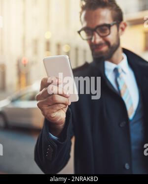 La tecnología inalámbrica satisface sus necesidades modernas. un hombre con estilo usando su teléfono en la ciudad. Foto de stock