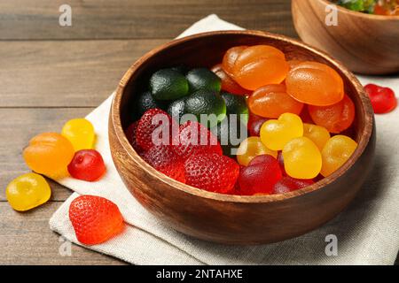 https://l450v.alamy.com/450ves/2ntahxe/deliciosos-caramelos-gomosos-en-tazon-sobre-mesa-de-madera-2ntahxe.jpg