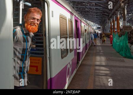 Un hombre musulmán con barba de color henna se encuentra en la entrada de un bogey de un tren suburbano en Chhatrapati Shivaji Maharaj Terminus en Mumbai, India Foto de stock