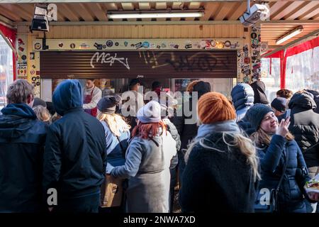 Los turistas hacen cola en grandes cantidades durante un día frío y soleado en el famoso Gemüse Kebap de Mustafa en Mehringdamm, Kreuzberg, Berlín, Alemania. Foto de stock