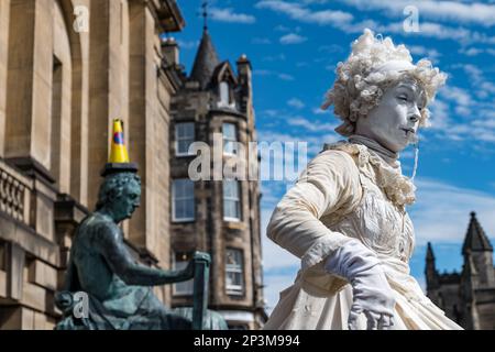 Mujer artista callejero vestida de blanco por la estatua de David Hume, Royal Mile, Edimburgo, Escocia, Reino Unido
