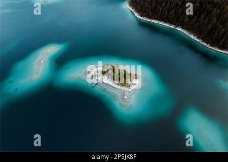 Una vista aérea de un archipiélago compuesto de islas en el lago Eibsee, rodeado de aguas cristalinas Foto de stock