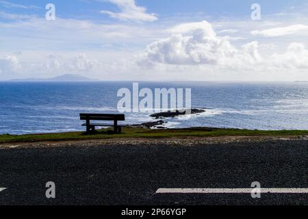 Banco solitario en el lado de la carretera a la playa de Keem en Achill Island, Co Mayo, Irlanda Foto de stock