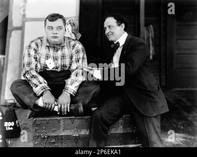 1923 ca : El actor de cómic mudo Roscoe ' Fatty ' Arbuckle ( 24 de marzo de 1887 Smith Center, Kansas, EE.UU. - 29 de junio de 1933 Nueva York, Nueva York, EE.UU. ) Con el célebre mago HARRY HOUDINI ( 24 de marzo de 1874 Budapest, Hungría - 31 de octubre de 1926 Detroit, Michigan, EE.UU. ) En Paramount studio set - CINE - PELÍCULA - franca - retrato - ritratto - atore - attrice - comico - corbata - cravatta - collar - colletto - papillon - lazo - mago - prestigiatore - bretelle - carta da juego - ilusionista - sonrisa - sorriso - comico - COMICHE ---- Archivio GBB Foto de stock