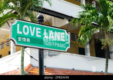 Señal de calle de Love Lane en George Town, Penang, Malasia con el edificio circundante como fondo. Foto de stock