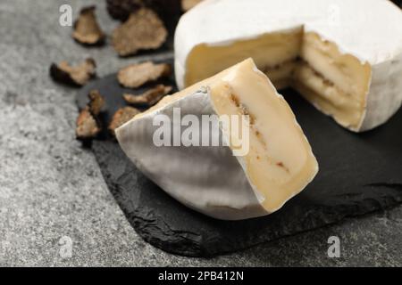 Delicioso queso de trufa en mesa gris, primer plano Foto de stock